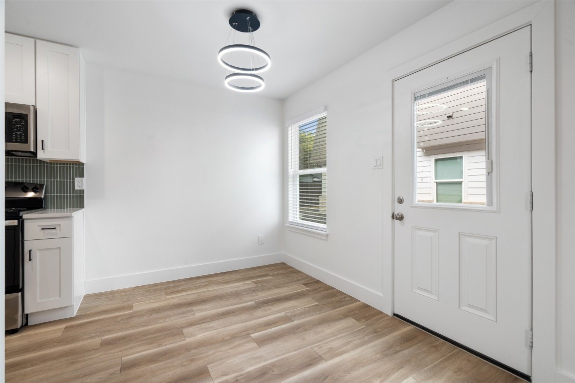 1901 Hearthstone Drive, Unit D Austin, TX 78757 - Photo 9 of 30 a view of an empty room with a window and wooden floor