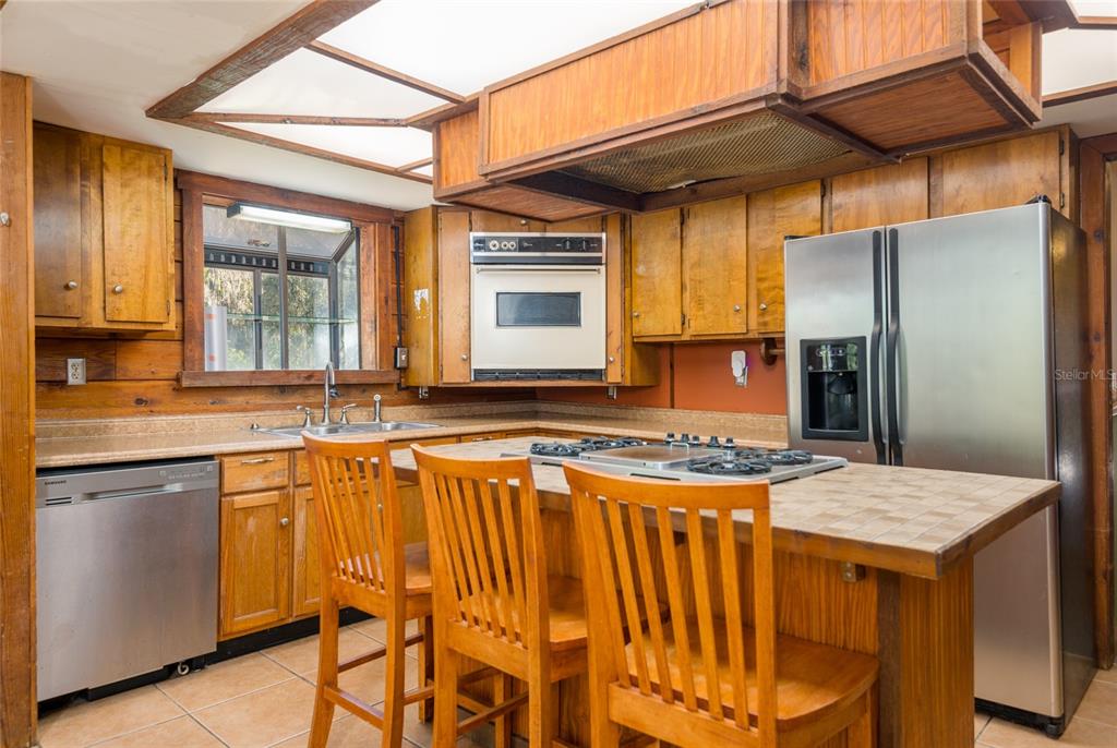 2641 McIntosh Road Dover, FL 33527 - Photo 12 of 58 a kitchen with stainless steel appliances granite countertop wooden cabinets a stove a sink and a refrigerator
