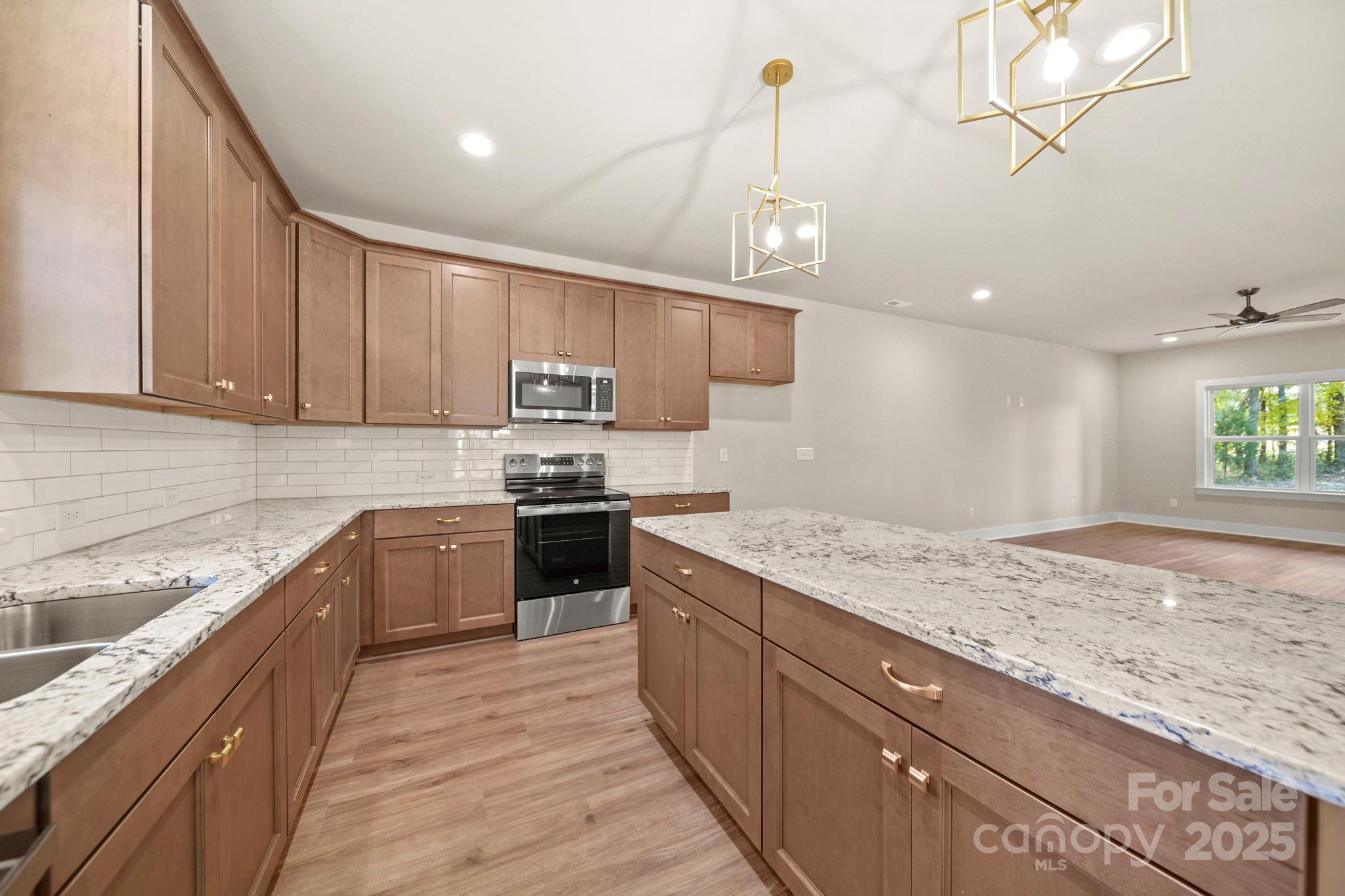 2601 Plyler Mill Road Monroe, NC 28112 - Photo 10 of 23 a kitchen with kitchen island granite countertop a sink a counter space appliances and cabinets