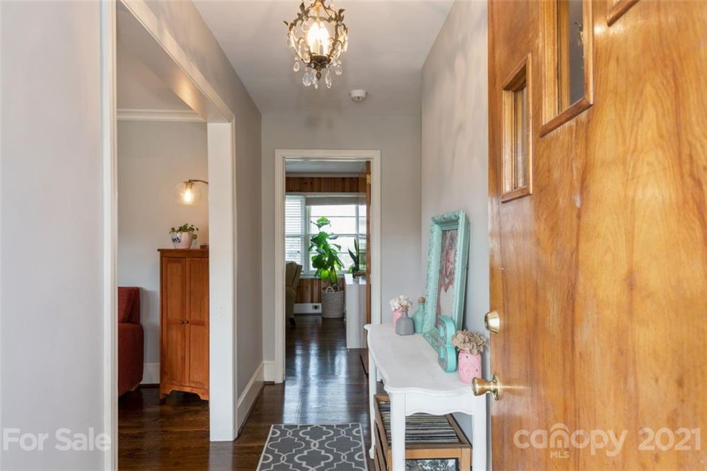 632 Scaleybark Road Charlotte, NC 28209 - Photo 11 of 36 a view of a hallway with wooden floor and a chandelier