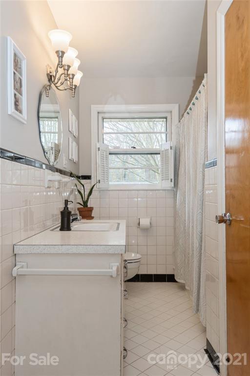 632 Scaleybark Road Charlotte, NC 28209 - Photo 26 of 36 a bathroom with a sink a toilet and mirror