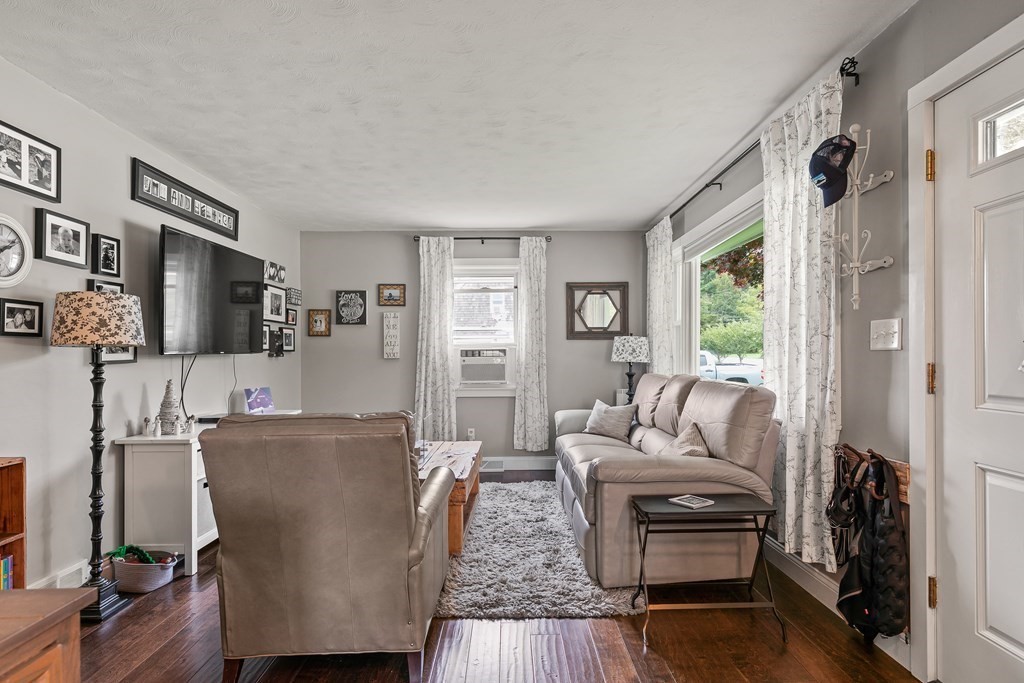 292 Cushman Road Rochester, MA 02770 - Photo 10 of 24 a living room with furniture a flat screen tv and a fireplace