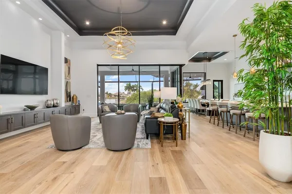 a living room with furniture a flat screen tv and a large window
