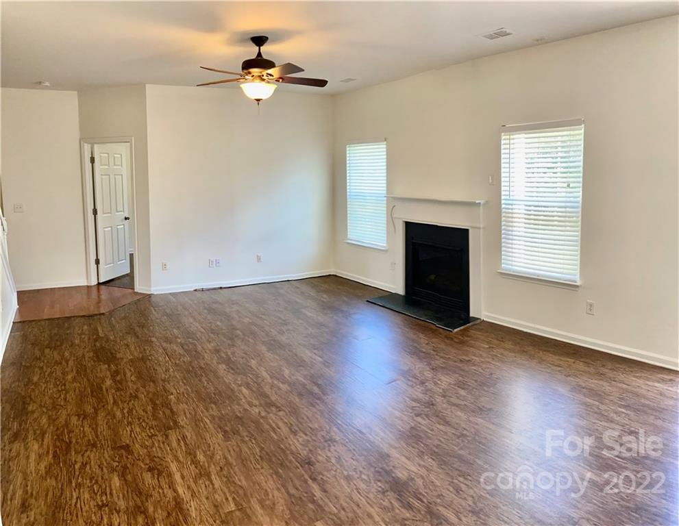 6432 Hermsley Road Charlotte, NC 28278 - Photo 12 of 32 an empty room with windows fireplace and a ceiling fan