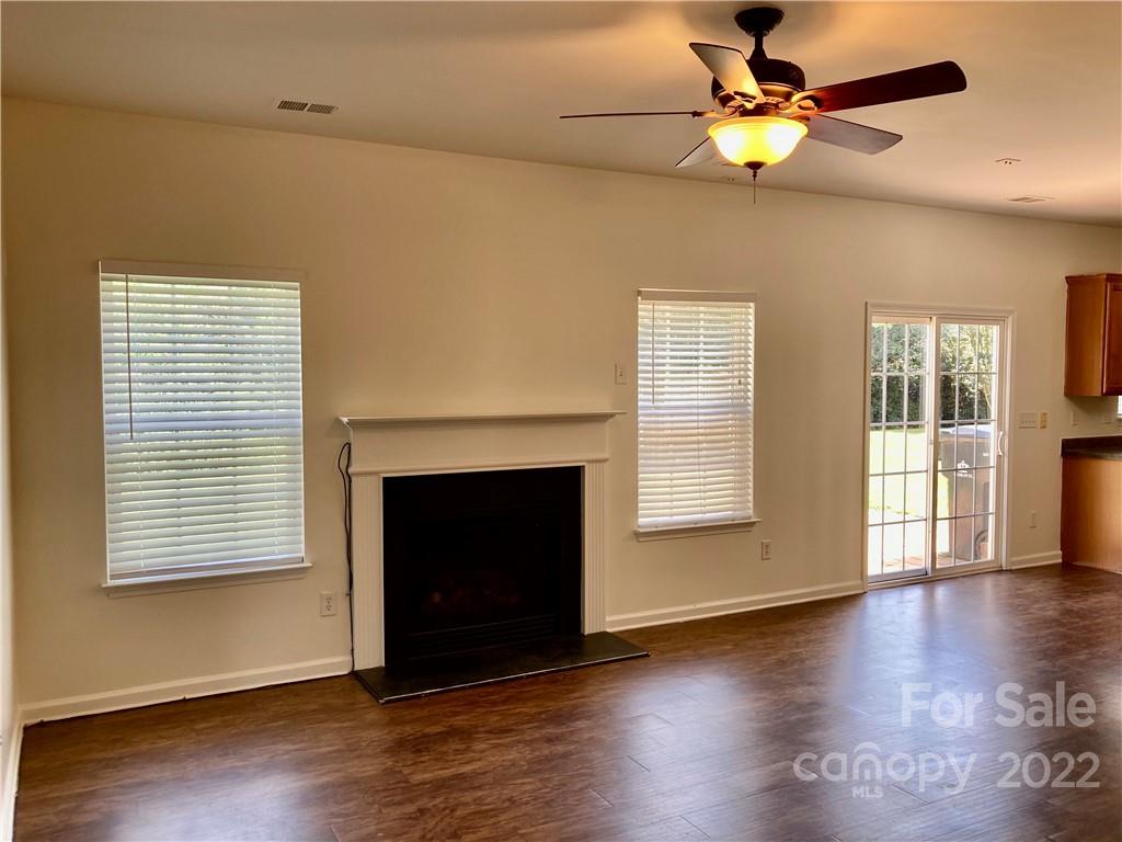 6432 Hermsley Road Charlotte, NC 28278 - Photo 10 of 32 a view of an empty room with wooden floor fireplace and a window