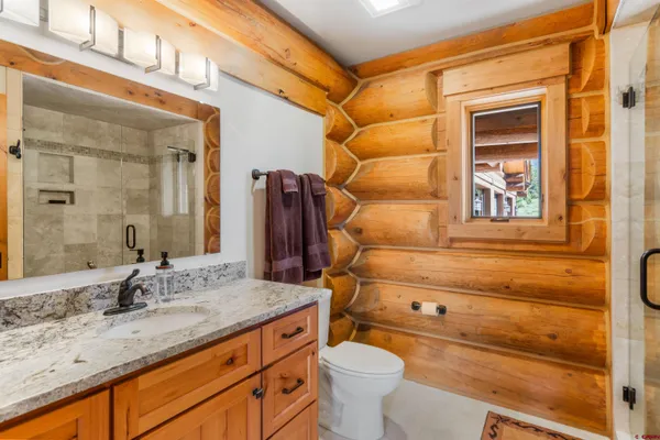 a bathroom with a granite countertop sink toilet and shower