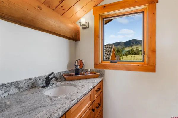 a bathroom with a granite countertop sink and a mirror