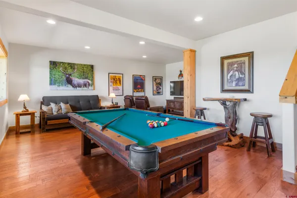 a room with furniture pool table and chairs