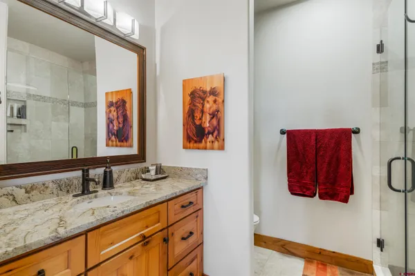 a bathroom with a granite countertop sink and a mirror