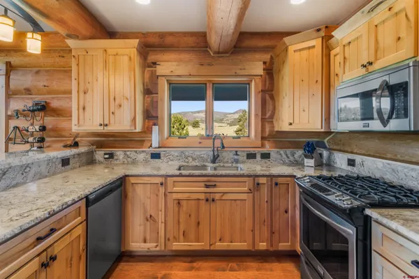 a kitchen with granite countertop a sink stove and cabinets