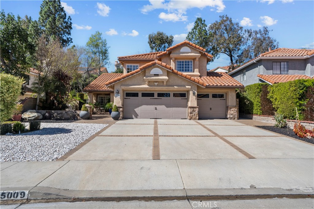 a front view of a house with a yard and trees