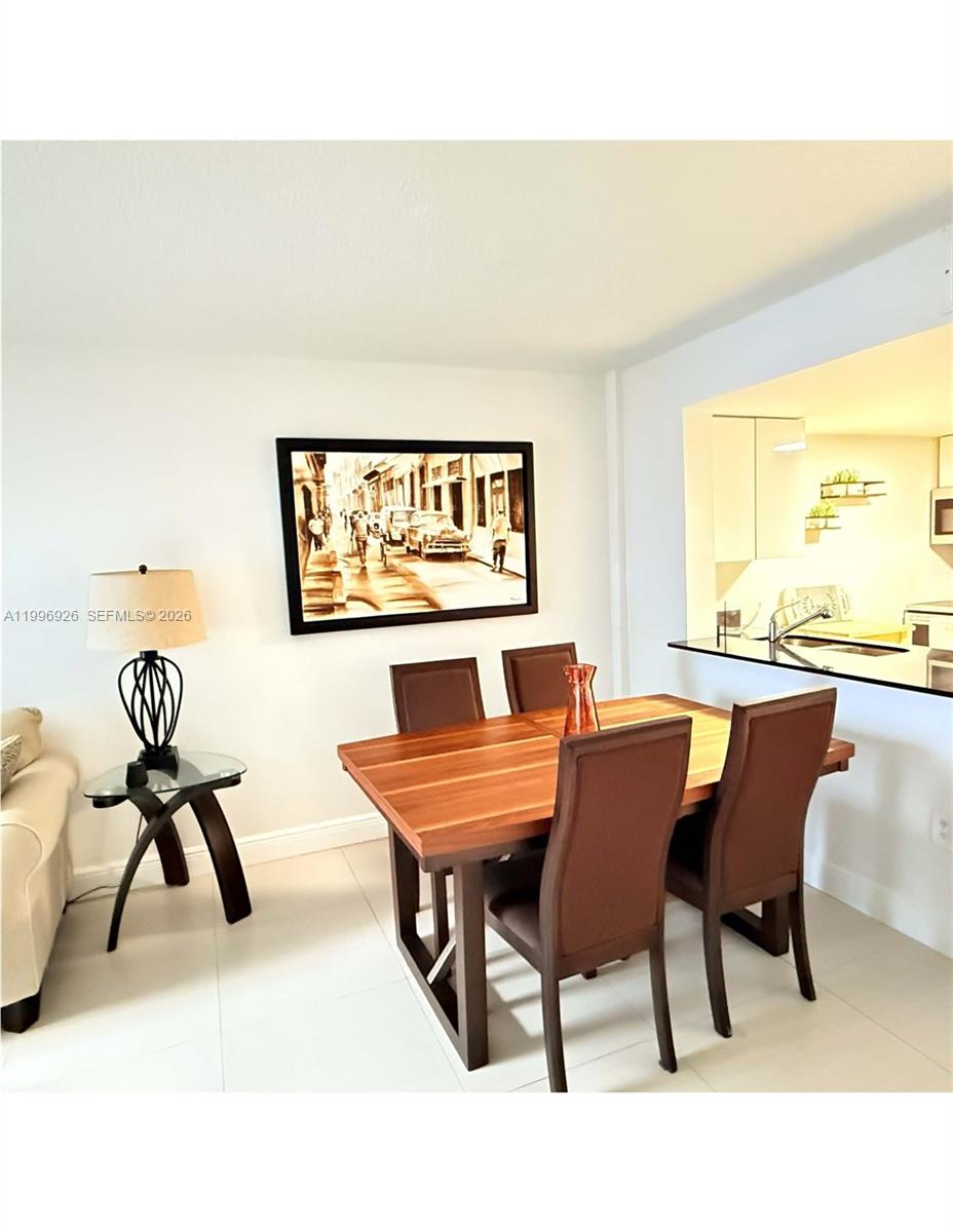 6801 Harding Avenue, Unit 301 Miami Beach, FL 33141 - Photo 6 of 10 a dining room with furniture and a large window