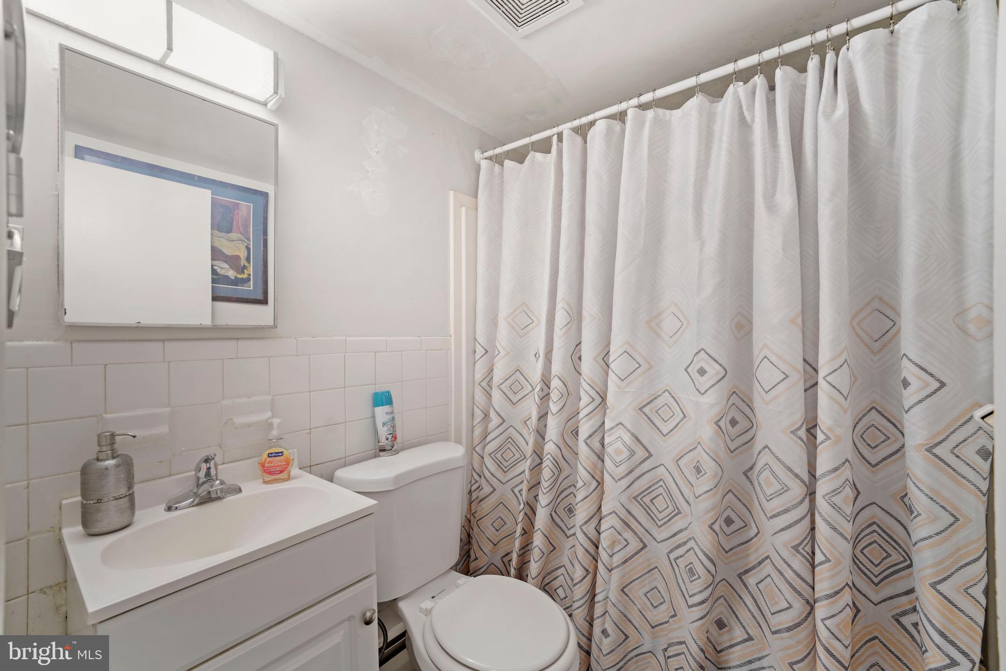 8115 West Chester Pike, Unit A8 Upper Darby, PA 19082 - Photo 17 of 17 a bathroom with a toilet sink and mirror