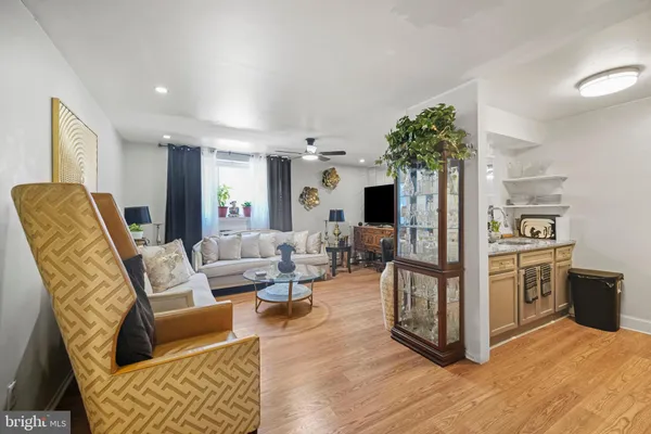 a living room with furniture a flat screen tv and a refrigerator