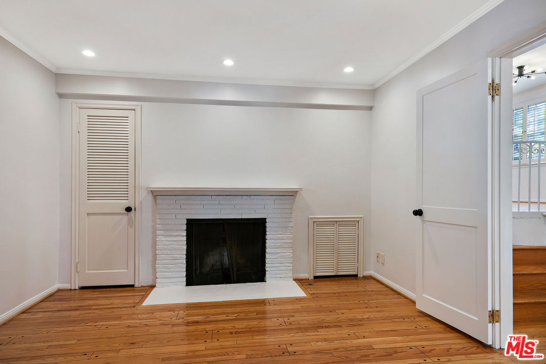 9601 Bolton Road Los Angeles, CA 90034 - Photo 13 of 33 a view of an empty room with wooden floor fireplace and a window