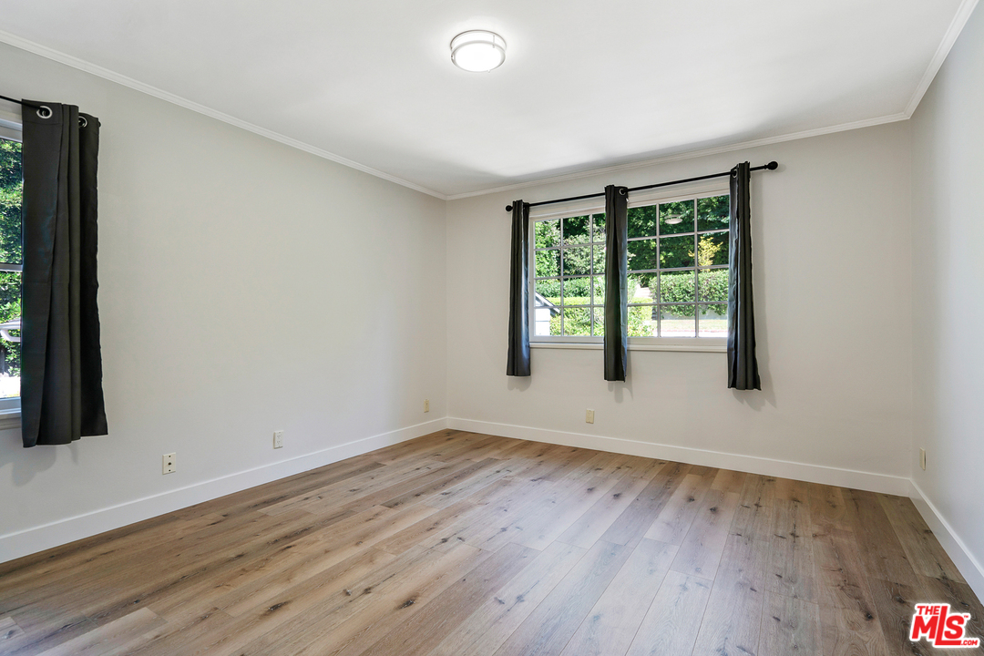 9601 Bolton Road Los Angeles, CA 90034 - Photo 16 of 33 an empty room with wooden floor and windows