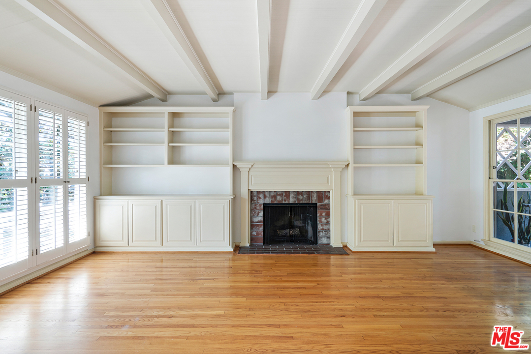 9601 Bolton Road Los Angeles, CA 90034 - Photo 7 of 33 a view of an empty room with wooden floor fireplace and a window