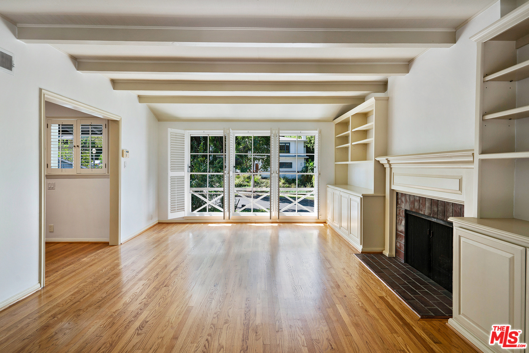 9601 Bolton Road Los Angeles, CA 90034 - Photo 8 of 33 a view of an empty room with wooden floor and a fireplace