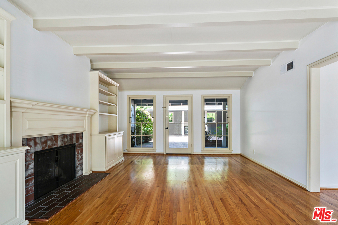 9601 Bolton Road Los Angeles, CA 90034 - Photo 9 of 33 a view of an empty room with wooden floor fireplace and a window