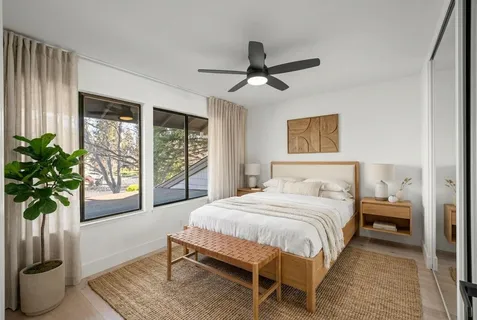 a bedroom with a large bed potted plant and a window