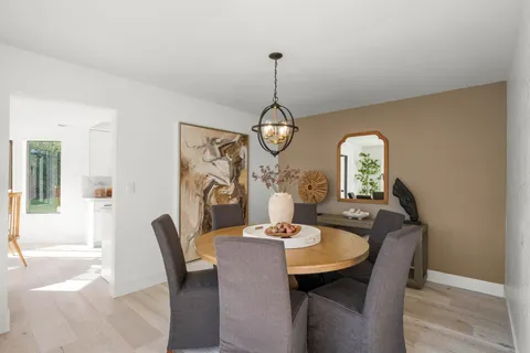 a dining room with furniture a chandelier and wooden floor