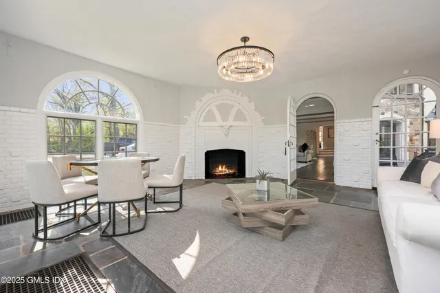 a living room with furniture a large window and a fireplace