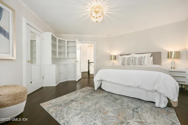 a spacious bedroom with a bed and a chandelier