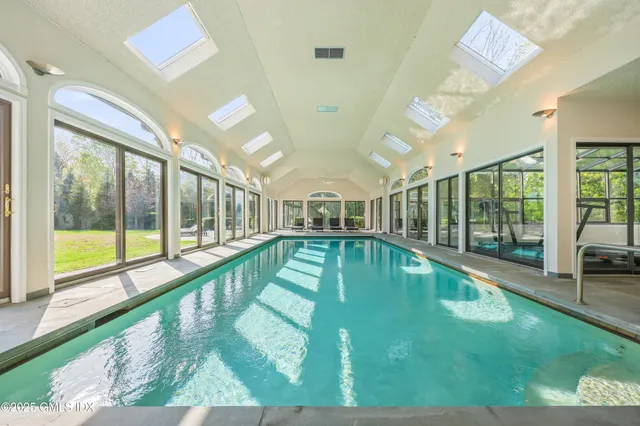 a swimming pool with outdoor seating and yard