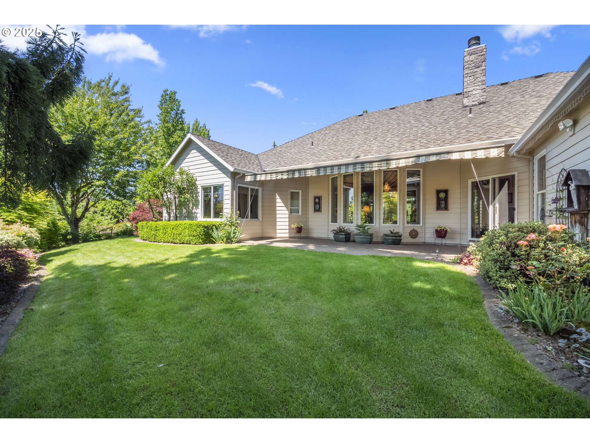18050 South Ridge Runner Road Oregon City, OR 97045 - Photo 33 of 40 a front view of a house with a yard table and chairs