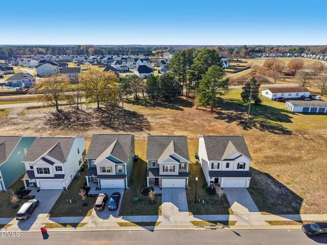 an aerial view of residential houses with yard