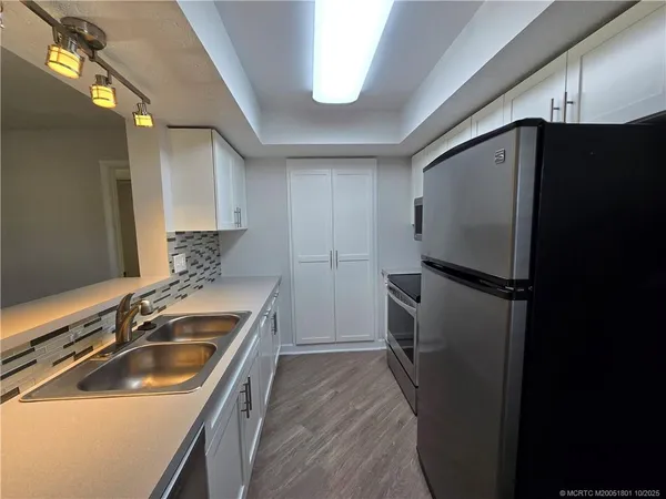 a kitchen that has a sink and a refrigerator