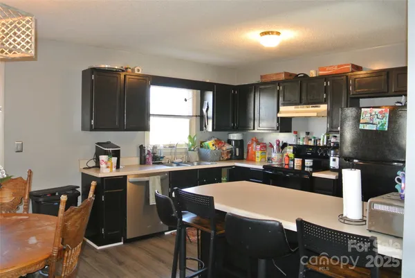 a kitchen with a dining table chairs and a refrigerator