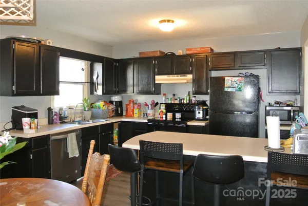 a kitchen with stainless steel appliances granite countertop a sink and a refrigerator