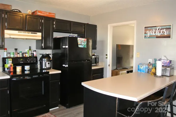 a kitchen with a sink a refrigerator and cabinets