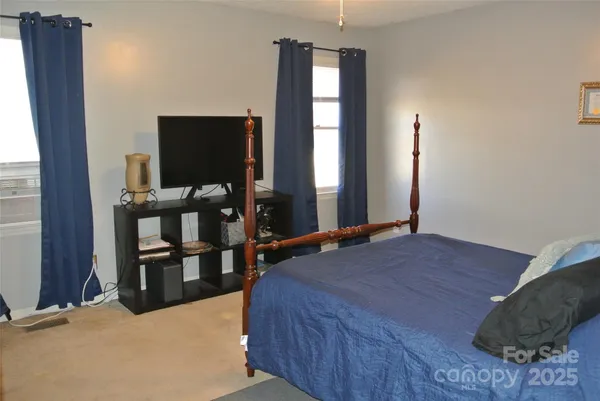 a bedroom with a bed and flat screen tv