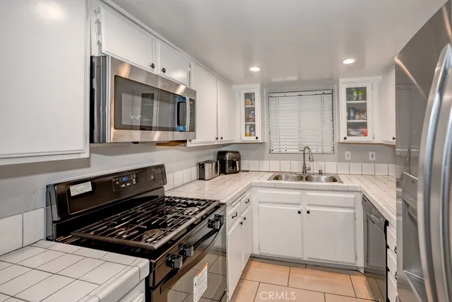 a kitchen with stainless steel appliances a sink stove and cabinets