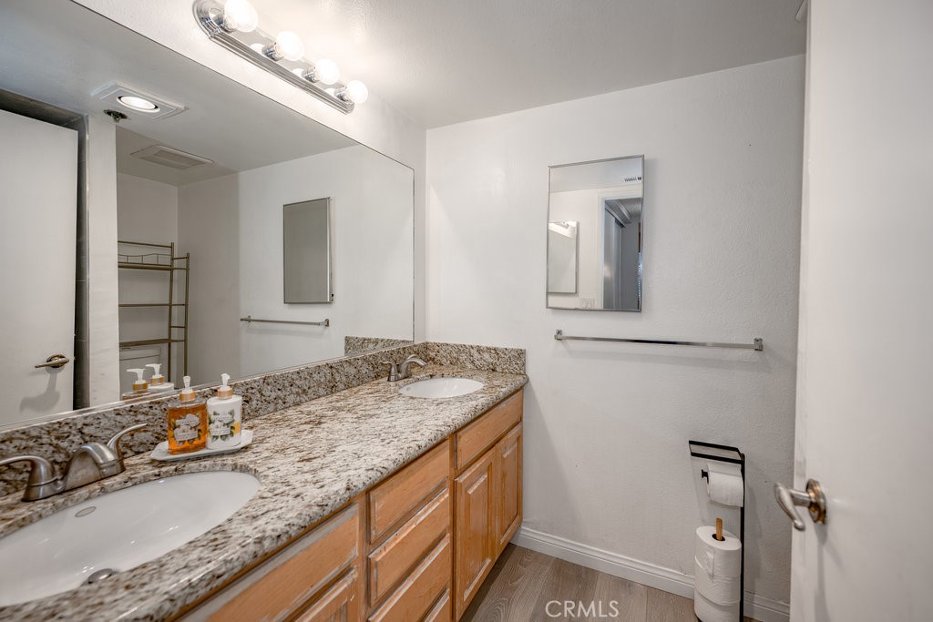 6545 Reseda Boulevard, Unit 3 Reseda, CA 91335 - Photo 7 of 12 a bathroom with a granite countertop sink and a mirror