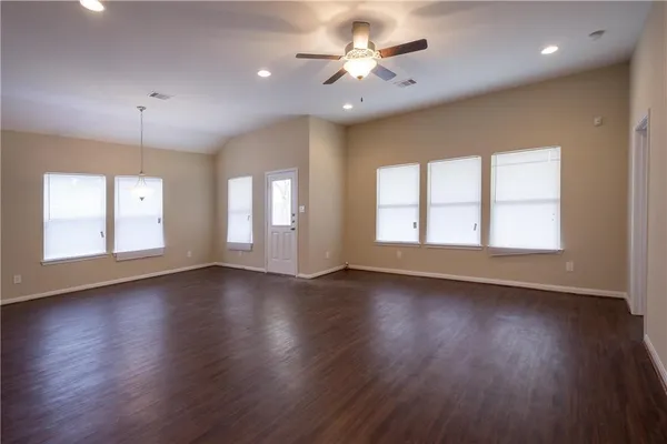 an empty room with wooden floor and window