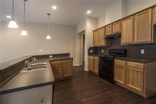 a kitchen that has a sink stainless steel appliances and cabinets