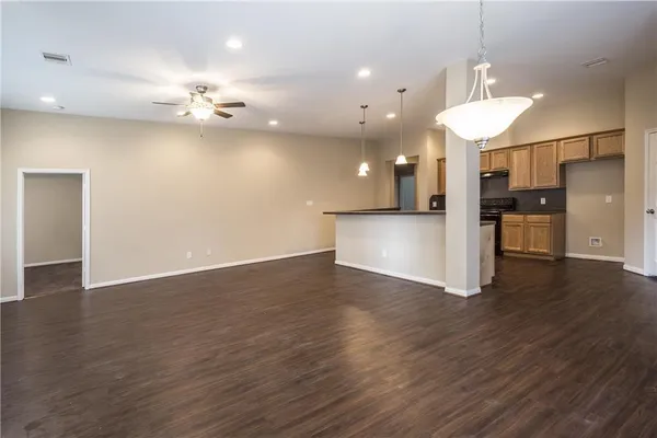 an open kitchen with a refrigerator and a stove top oven