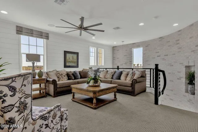 a living room with furniture and a ceiling fan