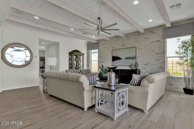 a living room with furniture a large window and a fireplace