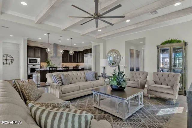 a living room with furniture kitchen view and a chandelier