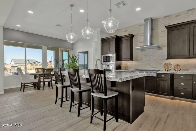 a kitchen with granite countertop a dining table chairs and wooden floor