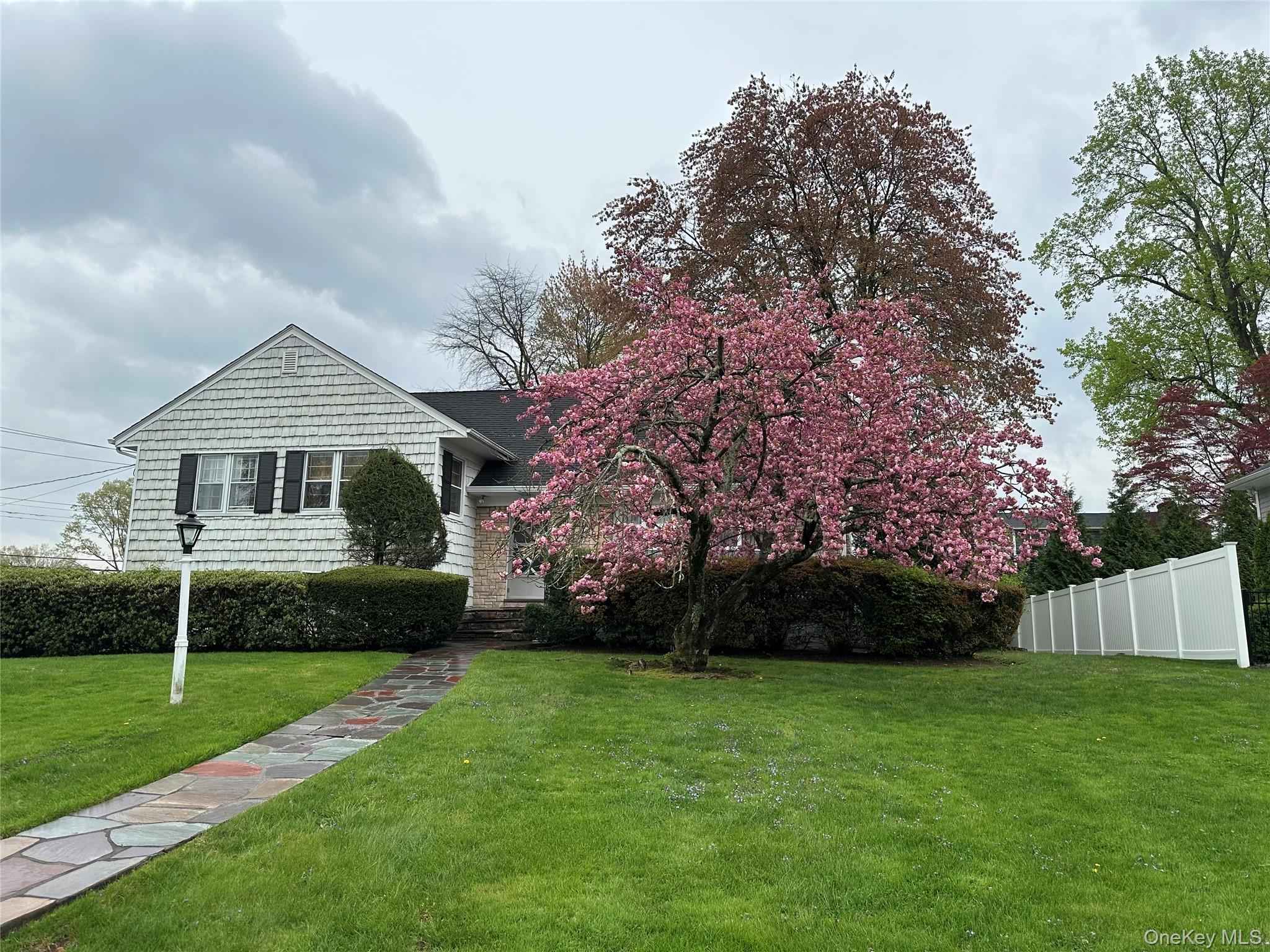 285 Stuart Drive New Rochelle, NY 10804 - Photo 1 of 37 a front view of a house with a garden and trees