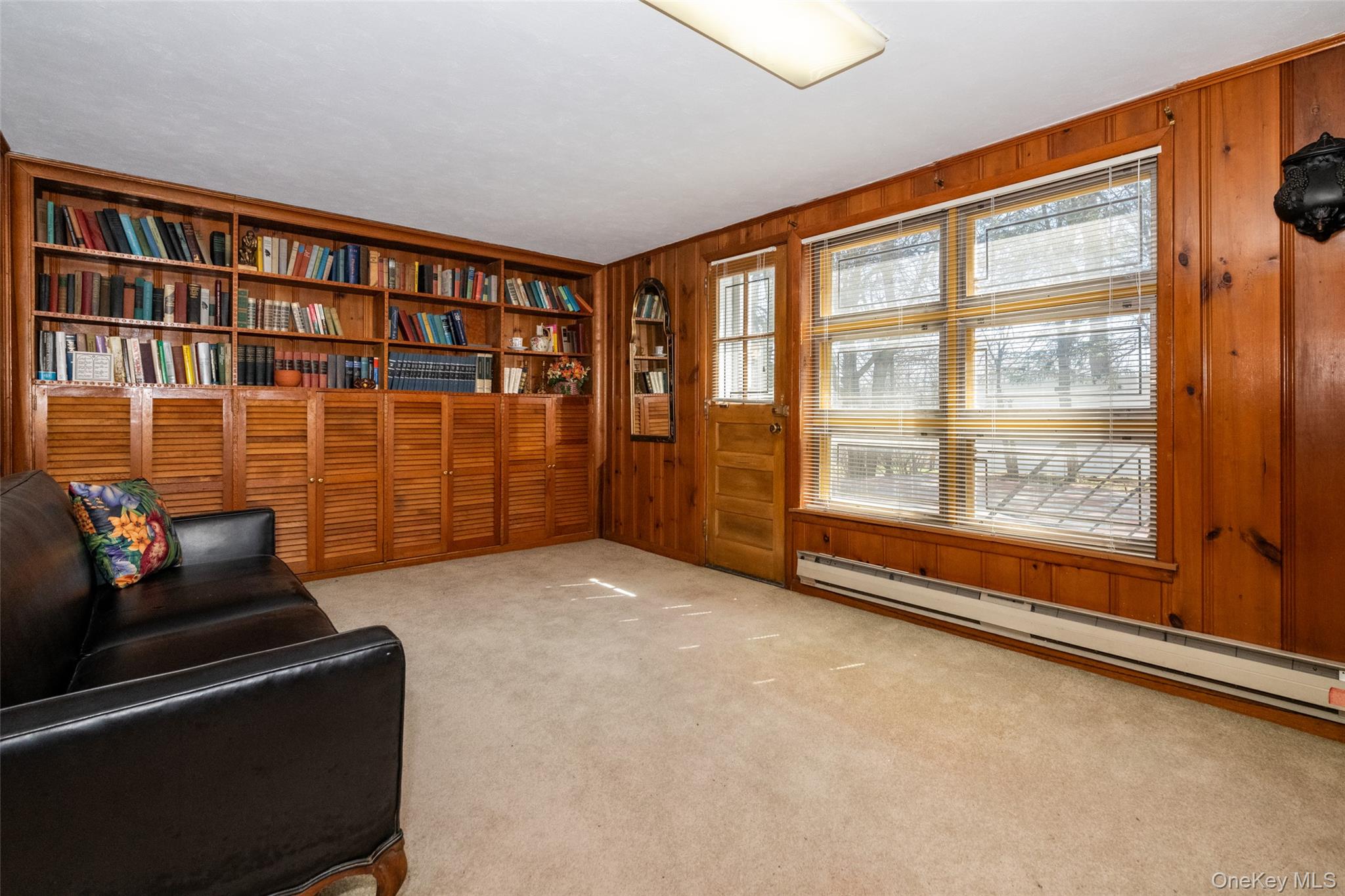 285 Stuart Drive New Rochelle, NY 10804 - Photo 23 of 37 a living room with furniture a lamp and a floor to ceiling window
