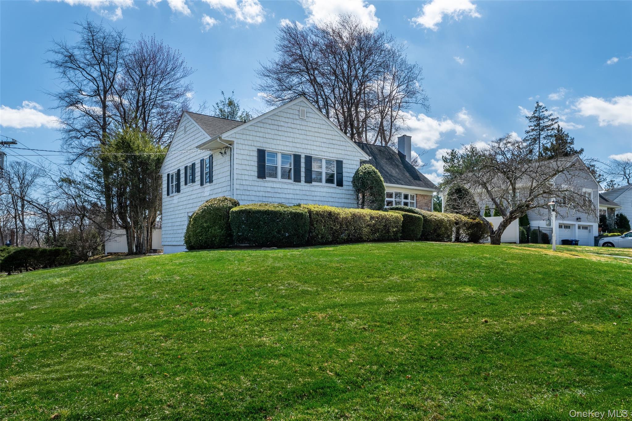 285 Stuart Drive New Rochelle, NY 10804 - Photo 34 of 37 a front view of a house with a garden and trees