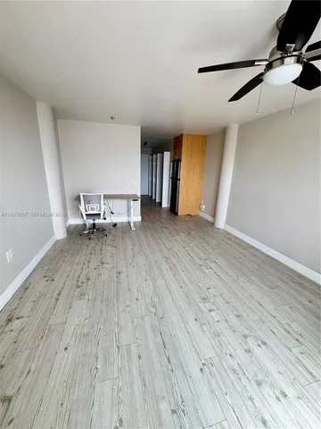 a view of a room with wooden floor and a window