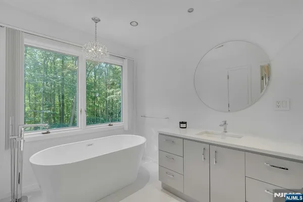 a bathroom with a double vanity sink a mirror and a bathtub