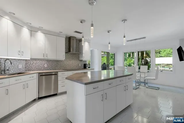 a kitchen with white cabinets and sink